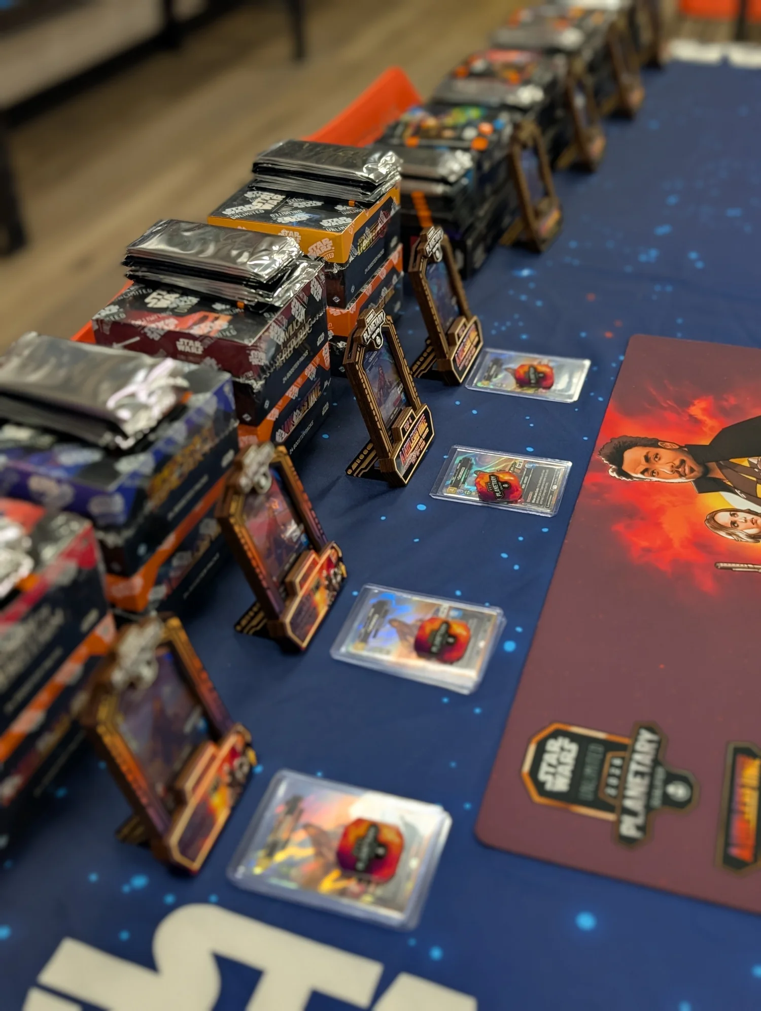 Engraved prize frames, coins, and card packs from the 802nd shop, staged on a Vermont tournament table.